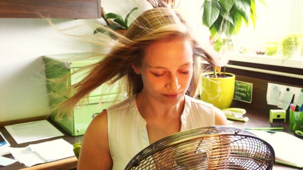 hot-summer-in-the-office-cooling-down-with-a-fan-GLHTBY9 (1)