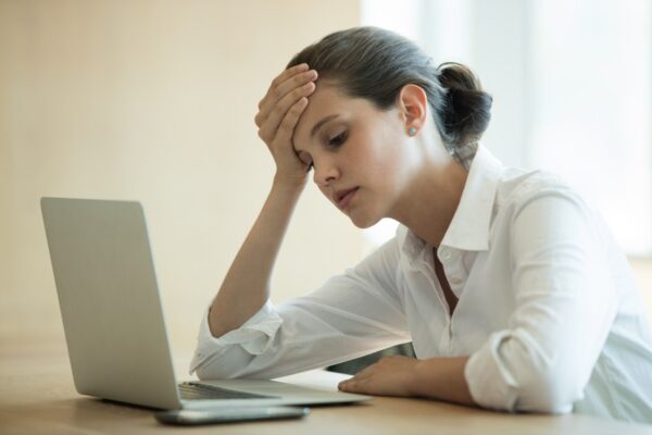 Tensed businesswoman using laptop in conference room